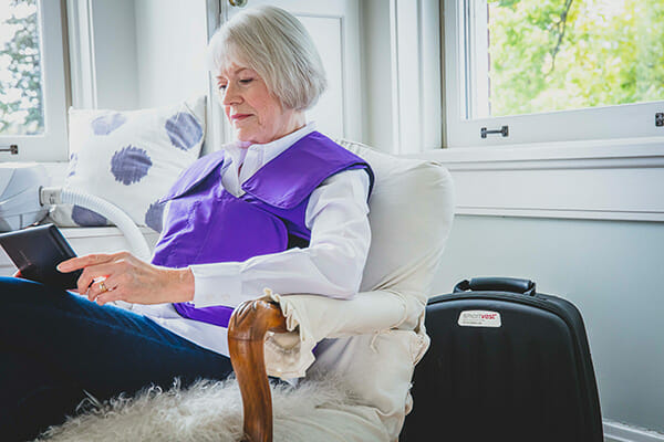 Woman reads a book while using her SmartVest