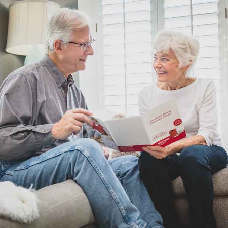 An older couple explores a SmartVest brochure together