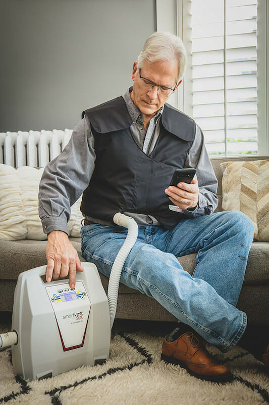 Older man wearing SmartVest and turning on machine