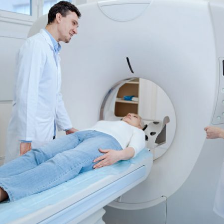 Doctors assisting a patient after placing her in an MRI machine
