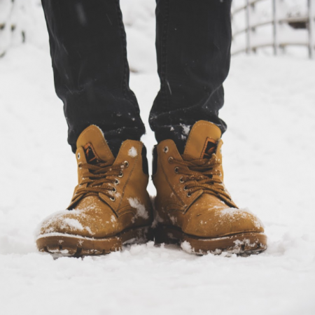 A person's boots standing in the snow