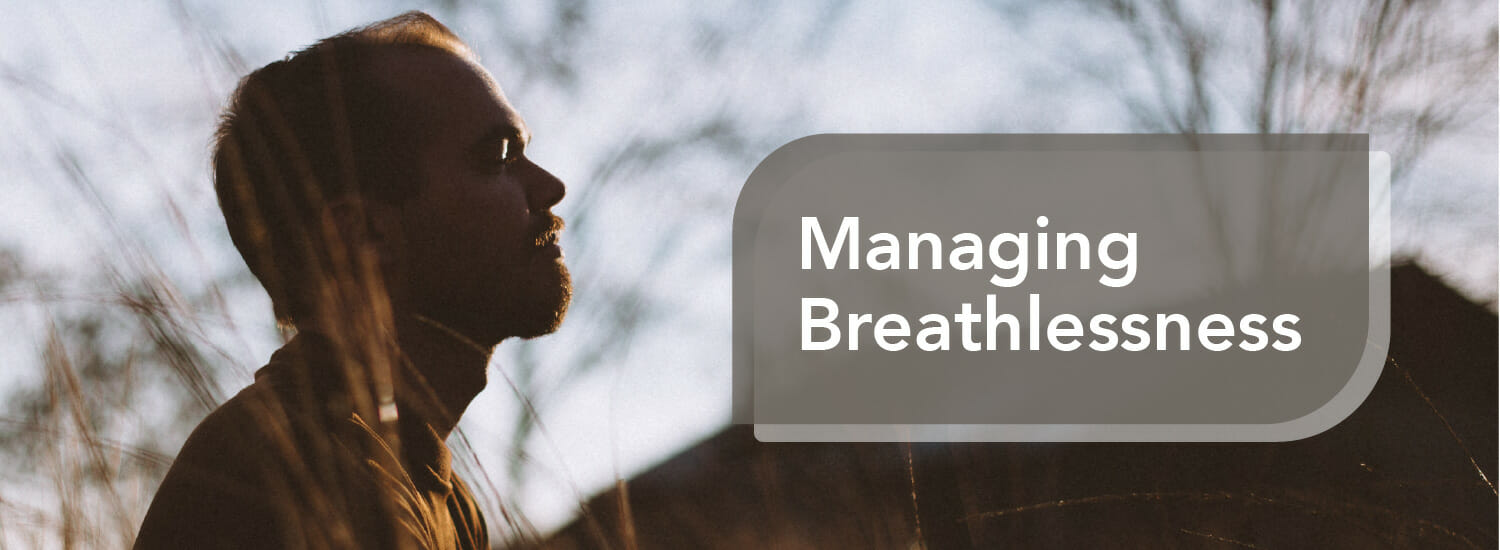 Man sitting in field managing breathlessness