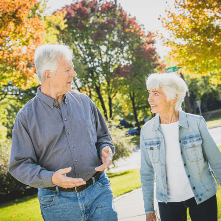 A couple discusses a topic while walking outdoors
