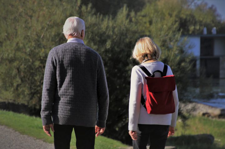 An older couple go for a walk outside