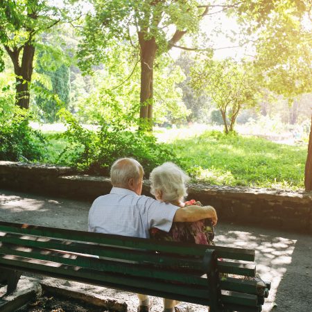 A couple embraces eachother on a scenic bench