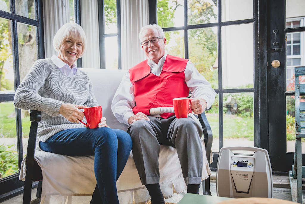 Two SmartVest users sitting in living room with coffee.