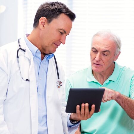 A doctor and his patient use a tablet