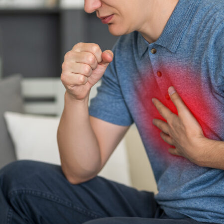 Man holding chest after experiencing a flare up.